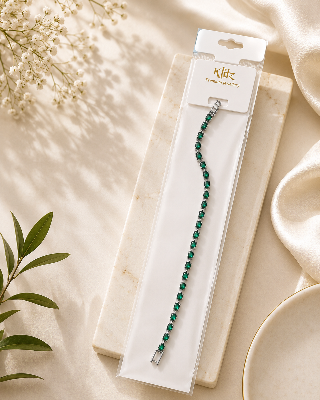Green tennis bracelet with emerald green stones on elegant Klitz premium jewellery packaging