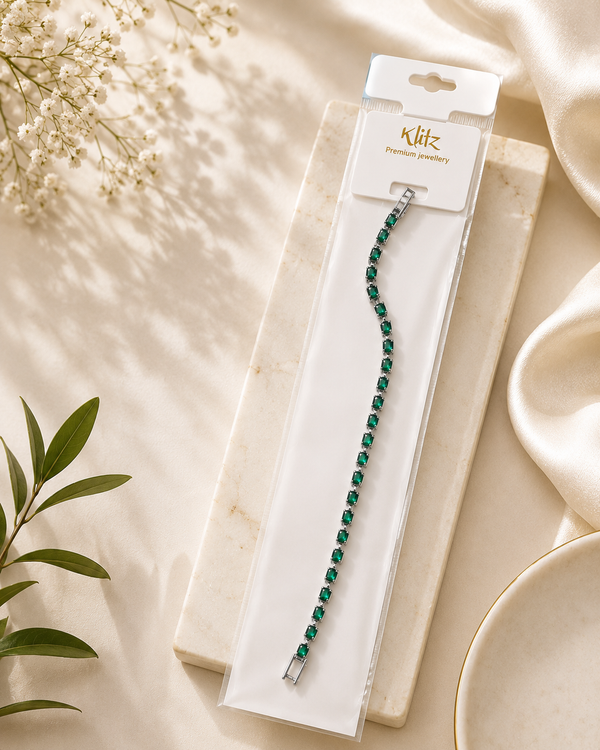 Green tennis bracelet with emerald green stones on elegant Klitz premium jewellery packaging