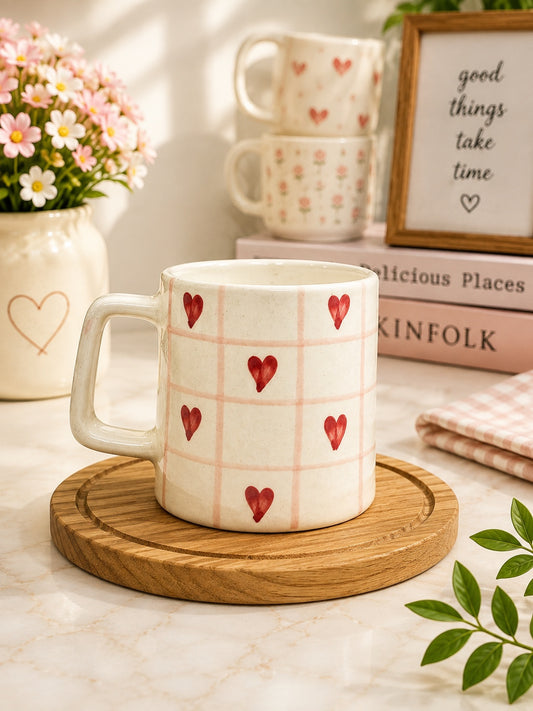 Cream ceramic mug with pink checkered pattern and red hearts